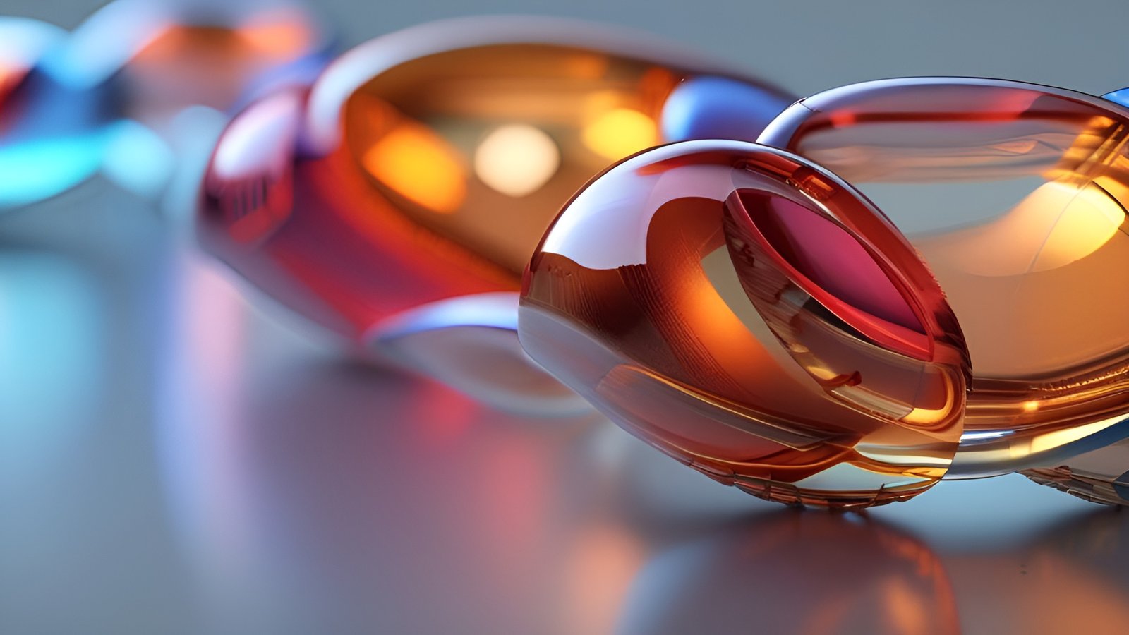 An abstract art of translucent amber red and blue glass ovals linked on a pale surface